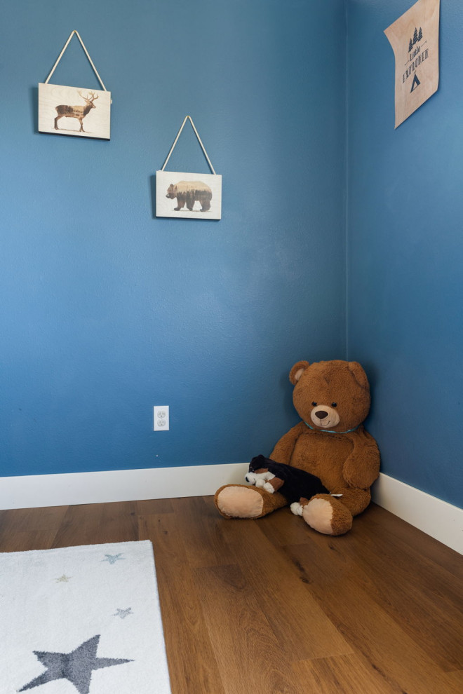 Exempel på ett mellanstort amerikanskt könsneutralt barnrum kombinerat med lekrum och för 4-10-åringar, med blå väggar, vinylgolv och brunt golv