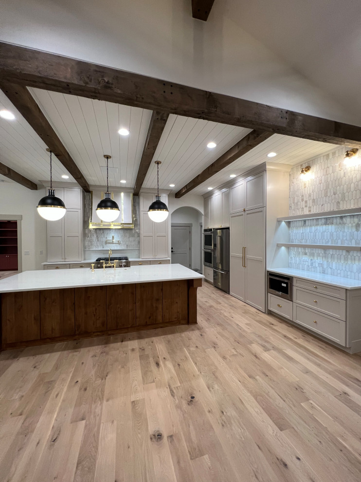 Inspiration for a large transitional l-shaped kitchen in Other with a farmhouse sink, shaker cabinets, beige cabinets, quartz benchtops, grey splashback, marble splashback, stainless steel appliances, light hardwood floors, with island, white benchtop and timber.
