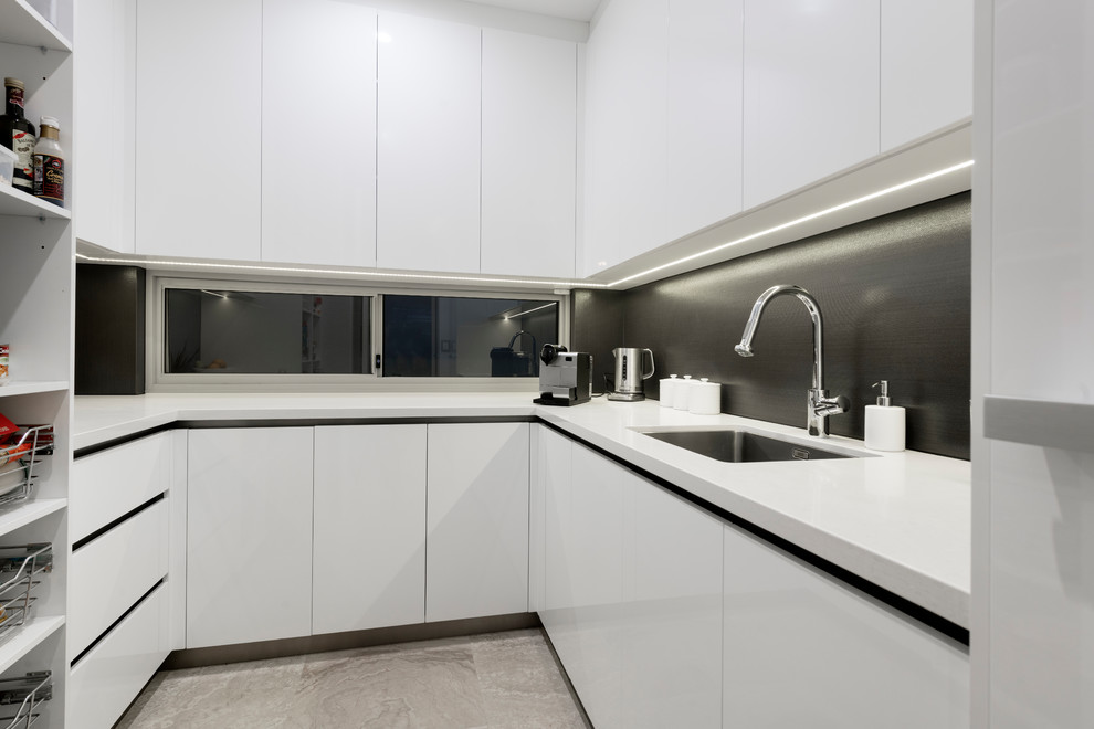 Inspiration for a small contemporary u-shaped separate kitchen in Perth with an undermount sink, recessed-panel cabinets, white cabinets, quartz benchtops, metallic splashback, ceramic splashback, limestone floors, grey floor and white benchtop.