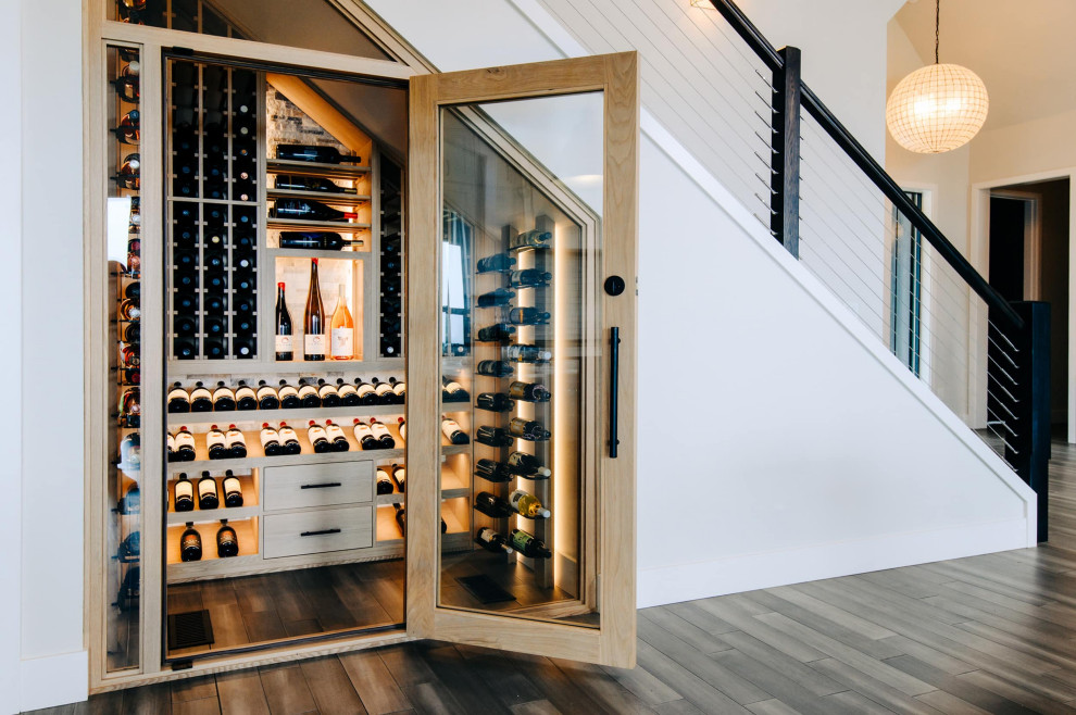 This is an example of a small modern wine cellar in Portland with medium hardwood floors, display racks and brown floor.