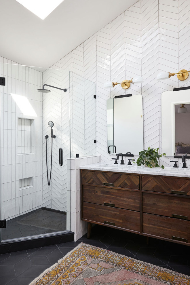 This is an example of a mid-sized midcentury master bathroom in San Francisco with brown cabinets, a corner shower, white tile, ceramic tile, porcelain floors, a drop-in sink, marble benchtops, black floor, a hinged shower door, a double vanity, a freestanding vanity and vaulted.
