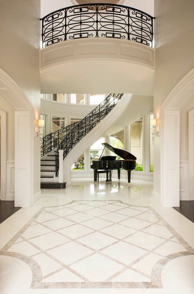 This is an example of a large transitional foyer in Dallas with grey walls and marble floors.