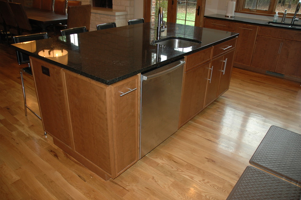 Inspiration for a transitional u-shaped eat-in kitchen remodel with an undermount sink, flat-panel cabinets, laminate countertops, white backsplash, stainless steel appliances and medium tone wood cabinets