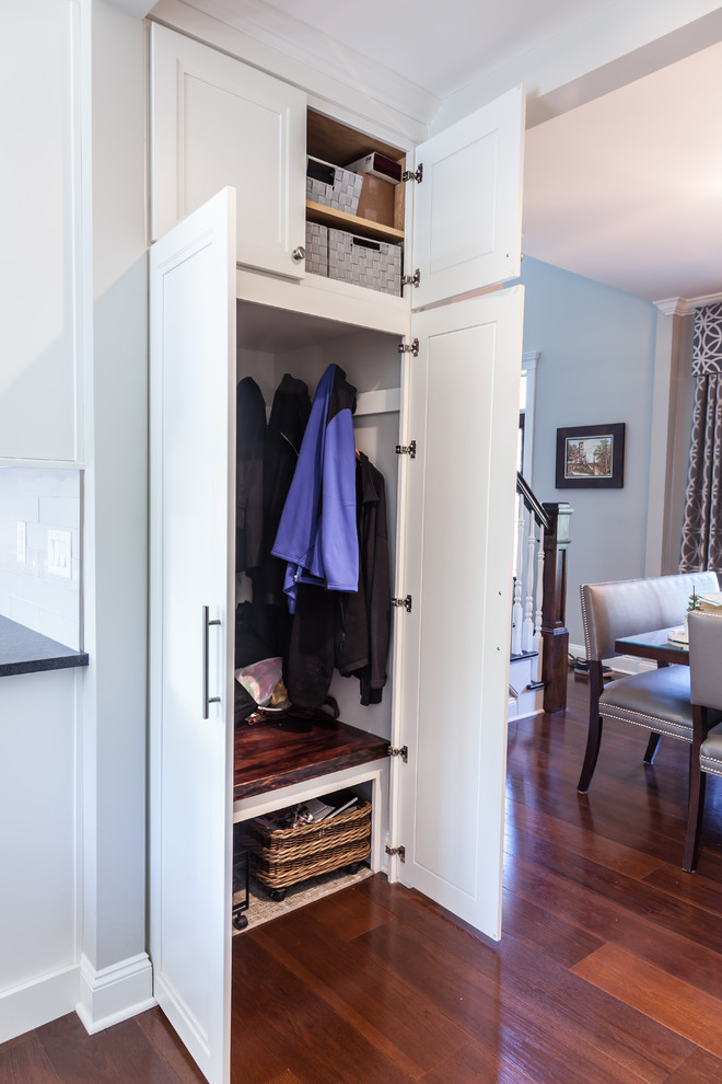 Mid-sized transitional gender-neutral built-in wardrobe in New York with recessed-panel cabinets, white cabinets, medium hardwood floors and brown floor.