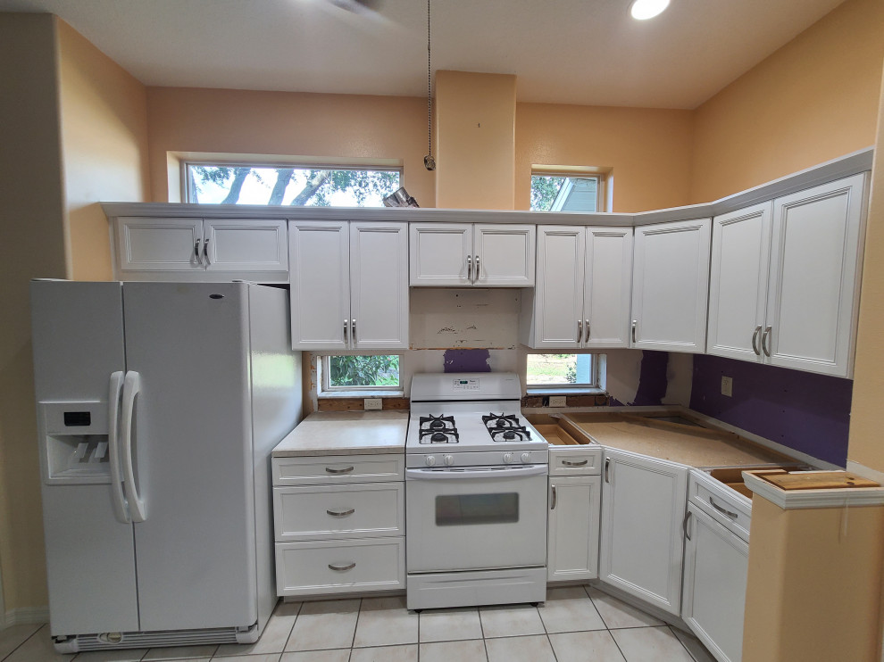 Example of a mid-sized u-shaped eat-in kitchen design with flat-panel cabinets and white cabinets