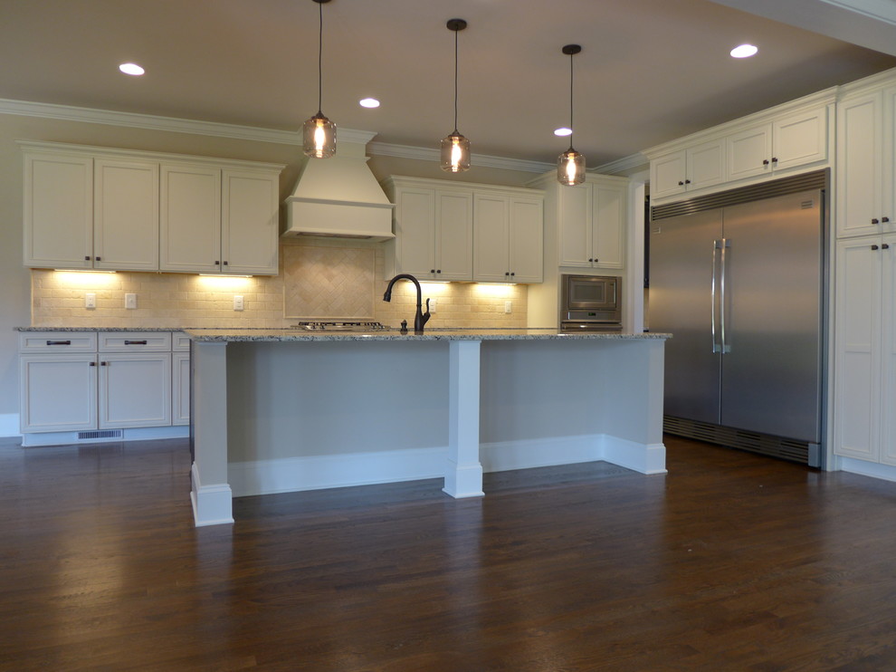 Open concept kitchen - large eclectic l-shaped medium tone wood floor open concept kitchen idea with a drop-in sink, white cabinets, granite countertops, white backsplash, porcelain backsplash, stainless steel appliances and an island