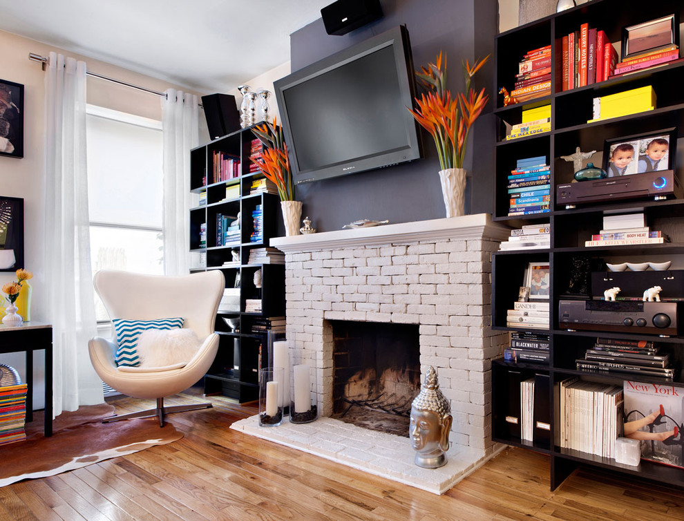 Traditional living room in New York with a library, a standard fireplace and a brick fireplace surround.