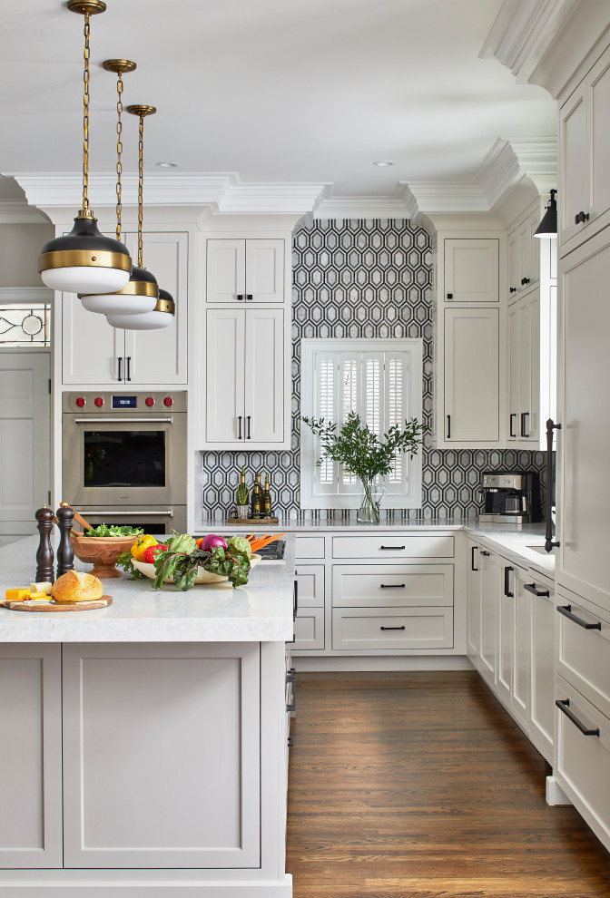Kitchen - large modern l-shaped dark wood floor kitchen idea in Atlanta with a single-bowl sink, white cabinets, quartz countertops, black backsplash, mosaic tile backsplash, paneled appliances, an island, gray countertops and beaded inset cabinets