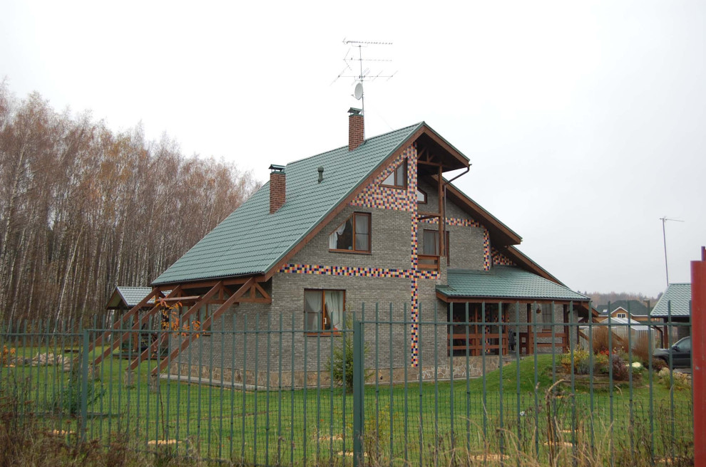 Foto de fachada de casa gris y azul contemporánea grande de tres plantas con revestimiento de piedra, tejado a dos aguas, tejado de teja de barro y tablilla