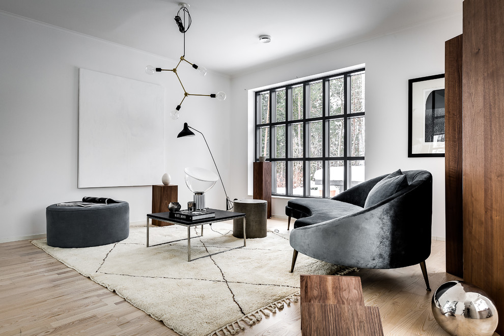 Design ideas for a modern formal living room in Stockholm with white walls, light hardwood floors and beige floor.