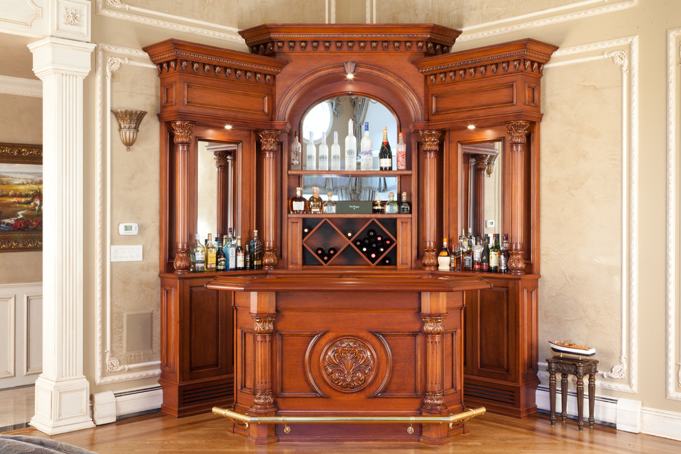 Small traditional home bar in New York with no sink, raised-panel cabinets, dark wood cabinets, granite benchtops, mirror splashback and white benchtop.