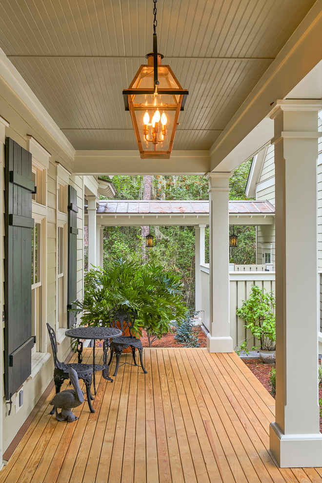 Design ideas for a mid-sized transitional front yard verandah in Charleston with decking and a roof extension.