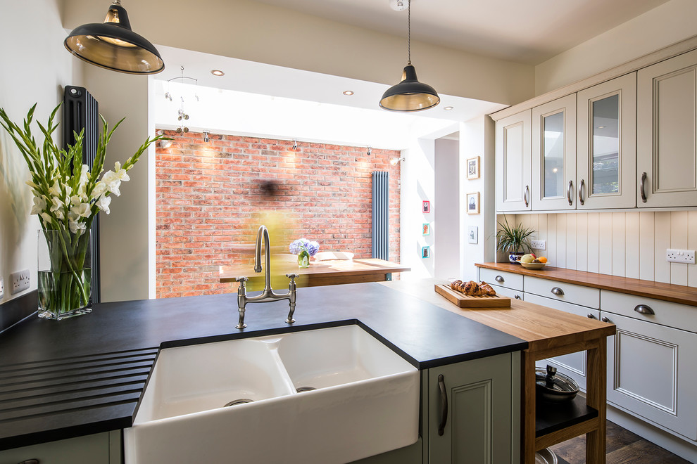 Photo of a large contemporary l-shaped eat-in kitchen in Other with a farmhouse sink, shaker cabinets, grey cabinets, white splashback, ceramic splashback, panelled appliances, medium hardwood floors, with island and brown floor.