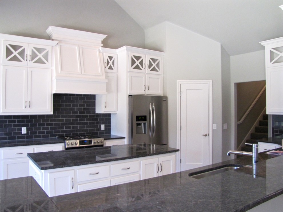 Open concept kitchen - transitional l-shaped ceramic tile open concept kitchen idea in Oklahoma City with an undermount sink, shaker cabinets, white cabinets, granite countertops, gray backsplash, subway tile backsplash, stainless steel appliances and an island