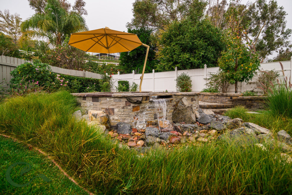 Mid-sized beach style backyard custom-shaped aboveground pool in Orange County with a hot tub and concrete pavers.