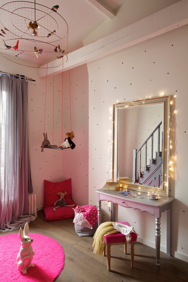 Large contemporary kids' playroom in Paris with medium hardwood floors and beige walls for kids 4-10 years old and girls.