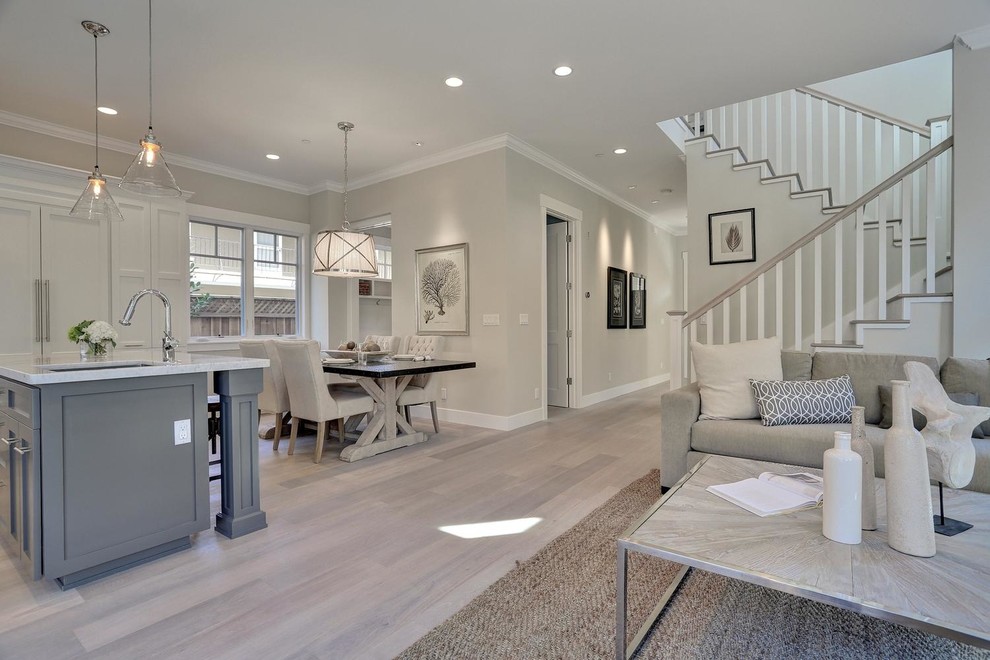 This is an example of a mid-sized transitional open concept living room in San Francisco with grey walls, light hardwood floors, no tv and grey floor.
