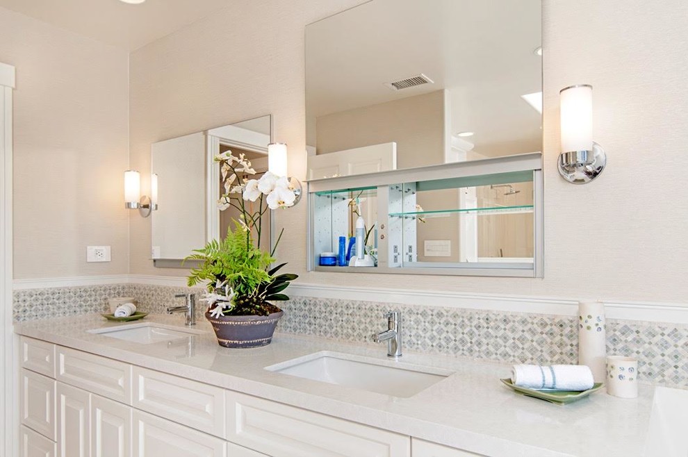 Photo of a large transitional master bathroom in San Diego with raised-panel cabinets, white cabinets, a freestanding tub, a double shower, white tile, white walls, limestone floors, an undermount sink, engineered quartz benchtops, a one-piece toilet, stone tile and white floor.