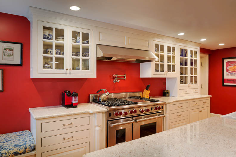 Inspiration for a mid-sized traditional l-shaped eat-in kitchen in Boston with a farmhouse sink, raised-panel cabinets, white cabinets, terrazzo benchtops, stainless steel appliances, with island and light hardwood floors.