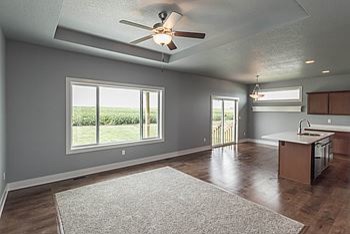 Eat-in kitchen - mid-sized transitional l-shaped medium tone wood floor eat-in kitchen idea with an undermount sink, recessed-panel cabinets, medium tone wood cabinets, quartz countertops, black appliances and an island