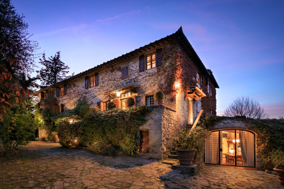 This is an example of a mediterranean three-storey beige house exterior in Other with stone veneer.
