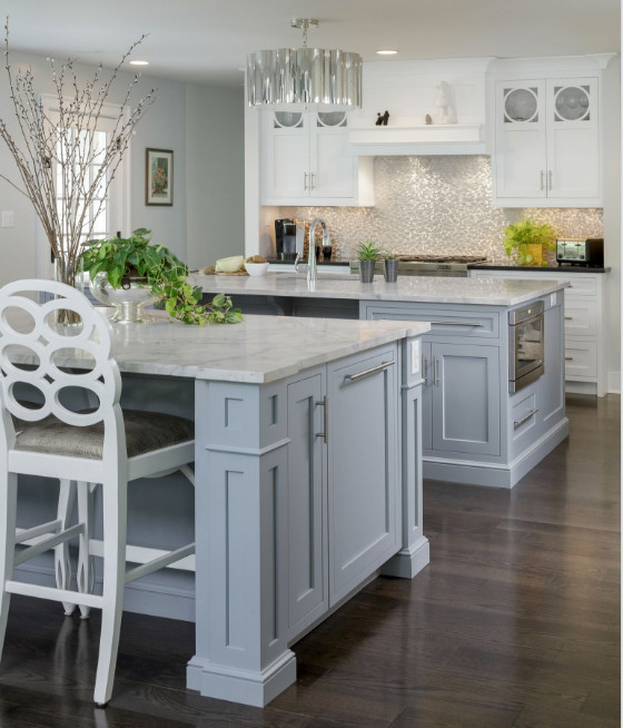 Design ideas for a large transitional l-shaped open plan kitchen in Philadelphia with an undermount sink, recessed-panel cabinets, grey cabinets, marble benchtops, metallic splashback, stainless steel appliances, dark hardwood floors, multiple islands and brown floor.