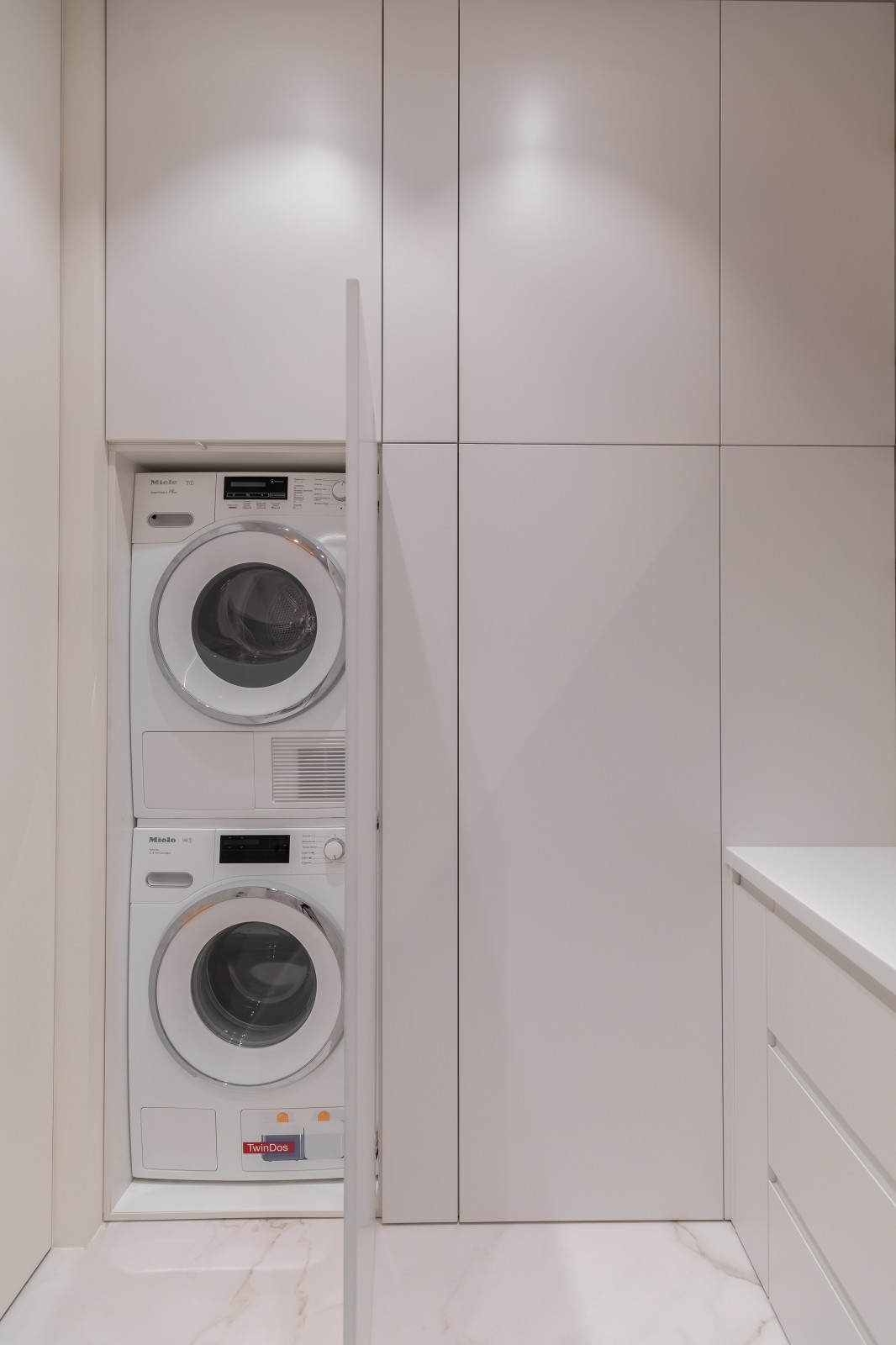 Стиральные машины, скрытые за настенной панелью в ванной