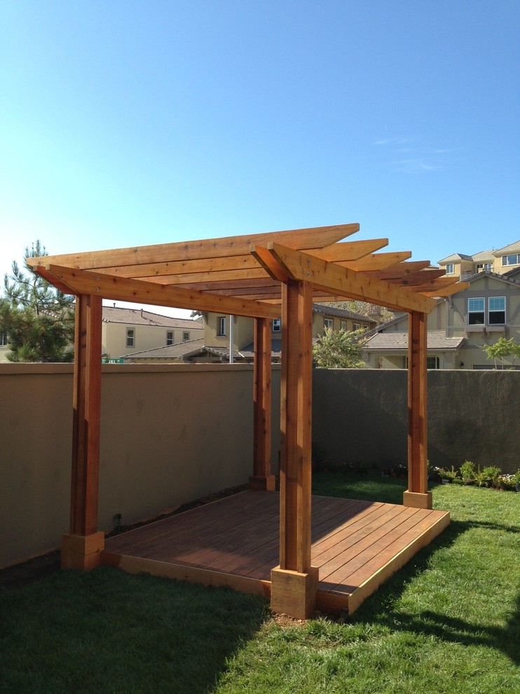 This is an example of a mid-sized asian backyard patio in Orange County with decking and a pergola.