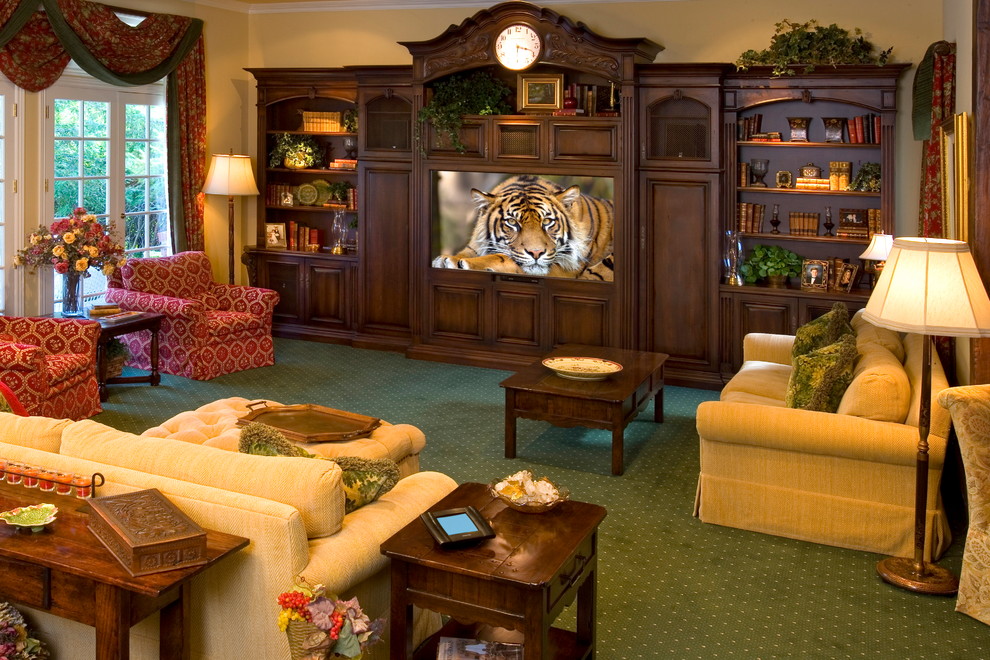 This is an example of a traditional home theatre in Los Angeles with a built-in media wall, carpet and green floor.