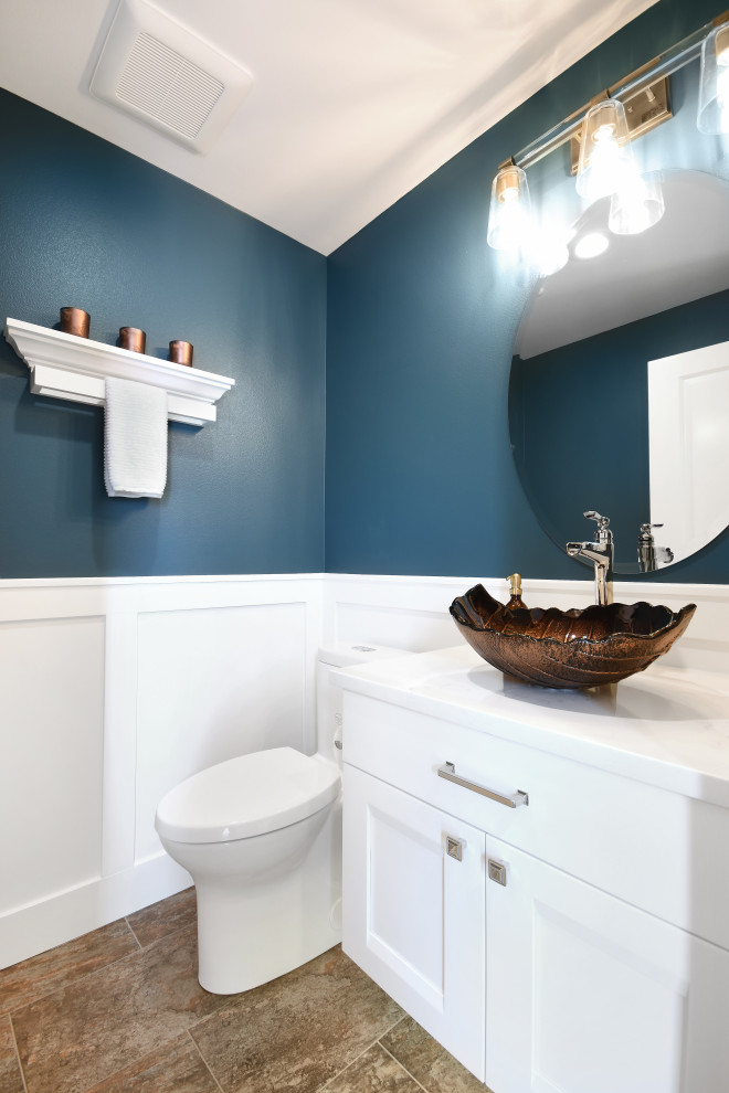 Пример оригинального дизайна: маленький туалет в стиле неоклассика (современная классика) с фасадами в стиле шейкер, белыми фасадами, унитазом-моноблоком, синей плиткой, синими стенами, полом из керамогранита, настольной раковиной, коричневым полом, белой столешницей, подвесной тумбой и панелями на стенах для на участке и в саду