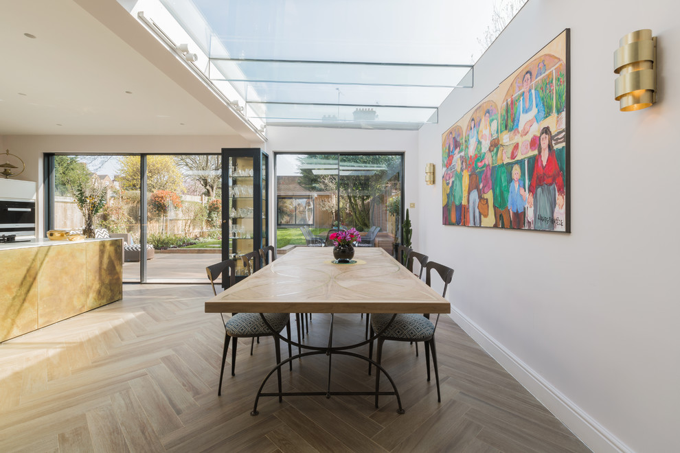 Contemporary open plan dining in London with grey walls, beige floor and porcelain floors.