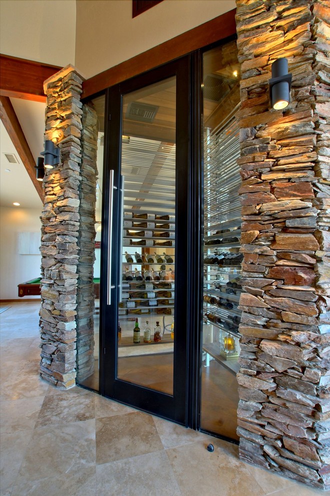 This is an example of a mid-sized wine cellar in Phoenix with storage racks and travertine floors.