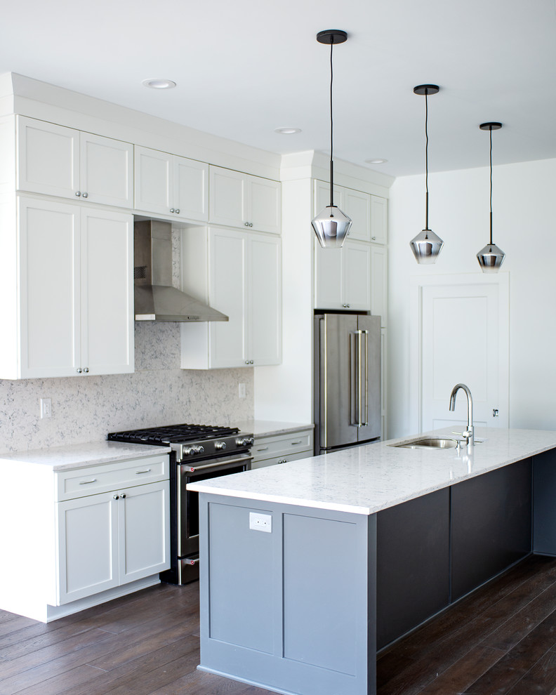 This is an example of a mid-sized contemporary single-wall eat-in kitchen in Indianapolis with an undermount sink, shaker cabinets, white cabinets, quartz benchtops, white splashback, stone slab splashback, stainless steel appliances, dark hardwood floors, with island, brown floor and white benchtop.