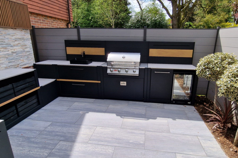 This is an example of a mid-sized contemporary backyard patio in Other with an outdoor kitchen, tile and no cover.