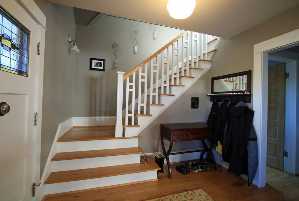 This is an example of a small arts and crafts wood u-shaped staircase in Portland with painted wood risers.