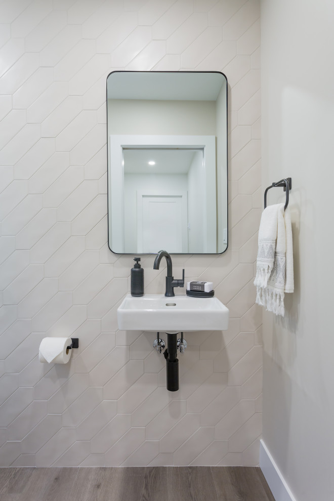 Aménagement d'un petit WC et toilettes classique avec WC à poser, un carrelage blanc, des carreaux de porcelaine, un mur blanc, un sol en vinyl, un lavabo suspendu et un sol gris.