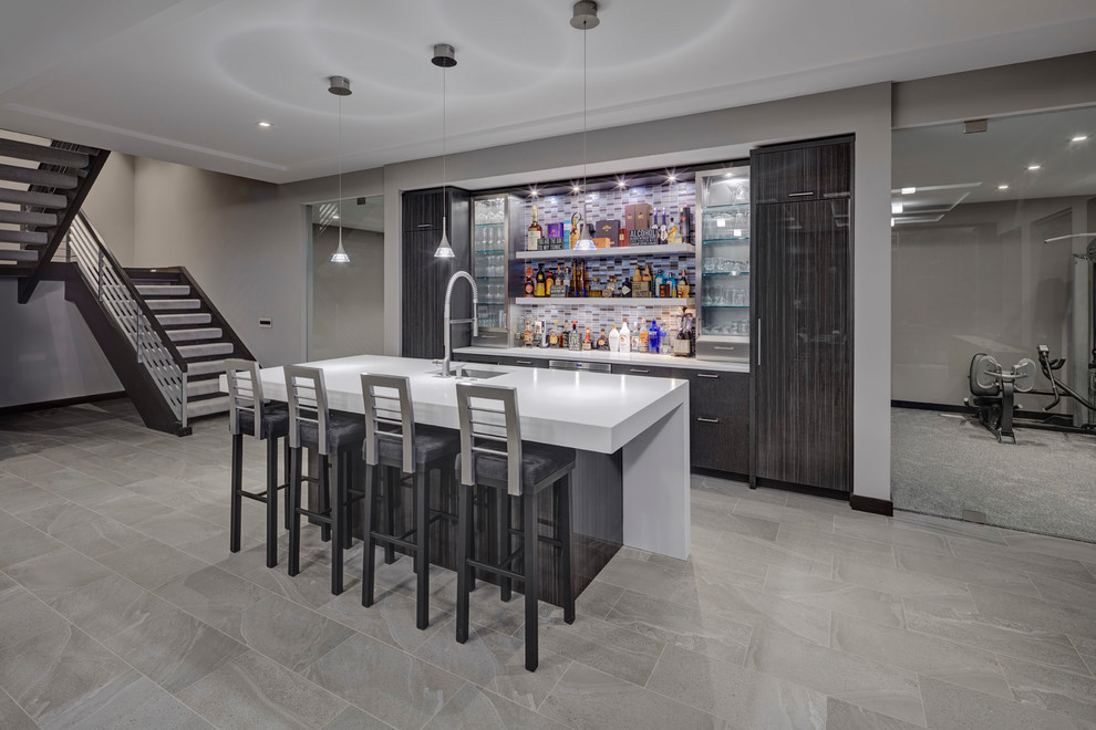 This is an example of a contemporary galley home bar in Detroit with an undermount sink, flat-panel cabinets, grey cabinets, grey splashback, mosaic tile splashback, grey floor and white benchtop.