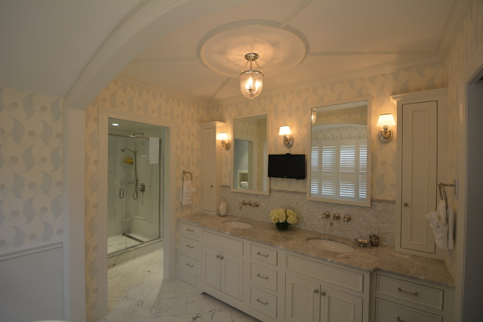 This is an example of a transitional master bathroom in Boston with an undermount sink, flat-panel cabinets, white cabinets, marble benchtops, a freestanding tub, an alcove shower, a two-piece toilet, white tile and marble floors.