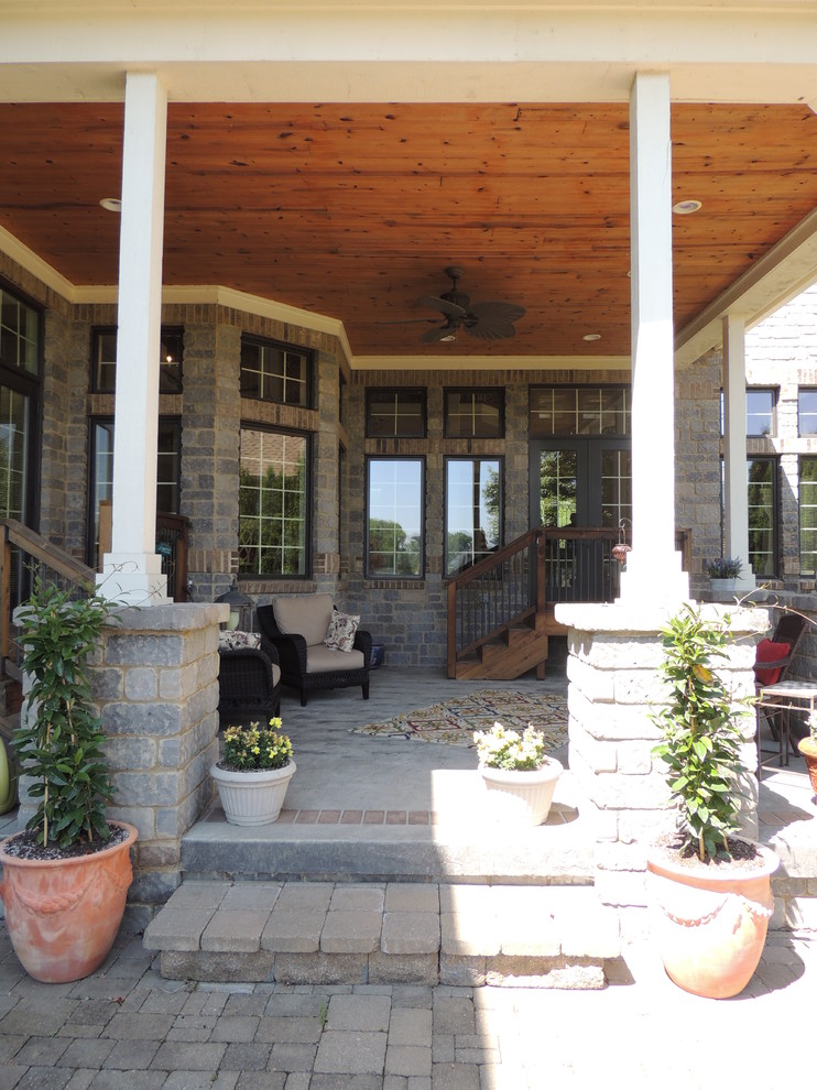 Large traditional backyard verandah in Indianapolis with a container garden, brick pavers and a roof extension.