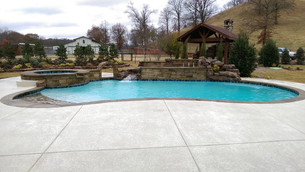 Inspiration for a rustic backyard stone and kidney-shaped lap pool fountain remodel
