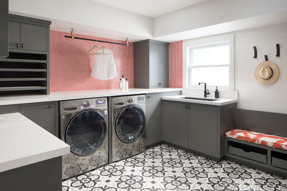 Photo of a large contemporary u-shaped utility room in San Francisco with an undermount sink, flat-panel cabinets, grey cabinets, ceramic floors, a side-by-side washer and dryer, white benchtop and wallpaper.