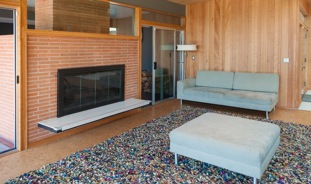 Photo of a mid-sized midcentury open concept living room in Portland with cork floors, a standard fireplace, a brick fireplace surround, vaulted and panelled walls.