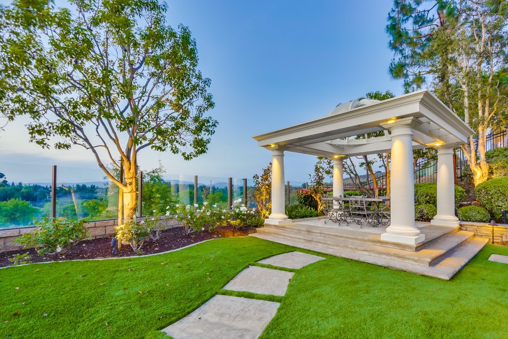 Traditional backyard patio in Orange County with concrete pavers and a gazebo/cabana.