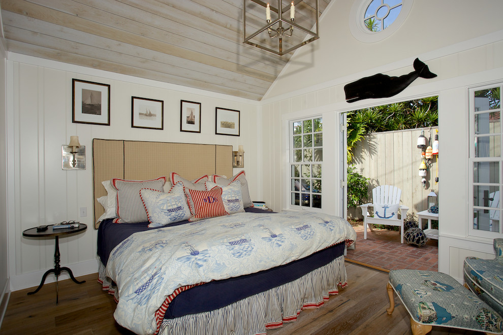 Photo of a beach style bedroom in San Diego with white walls, light hardwood floors and no fireplace.