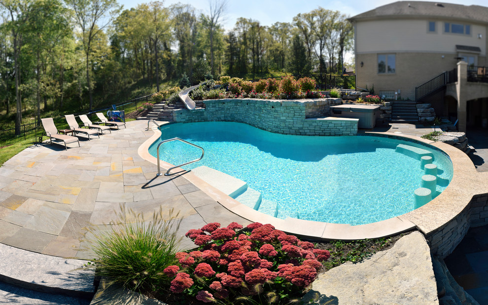 Example of a large transitional backyard stone and custom-shaped water slide design in Detroit