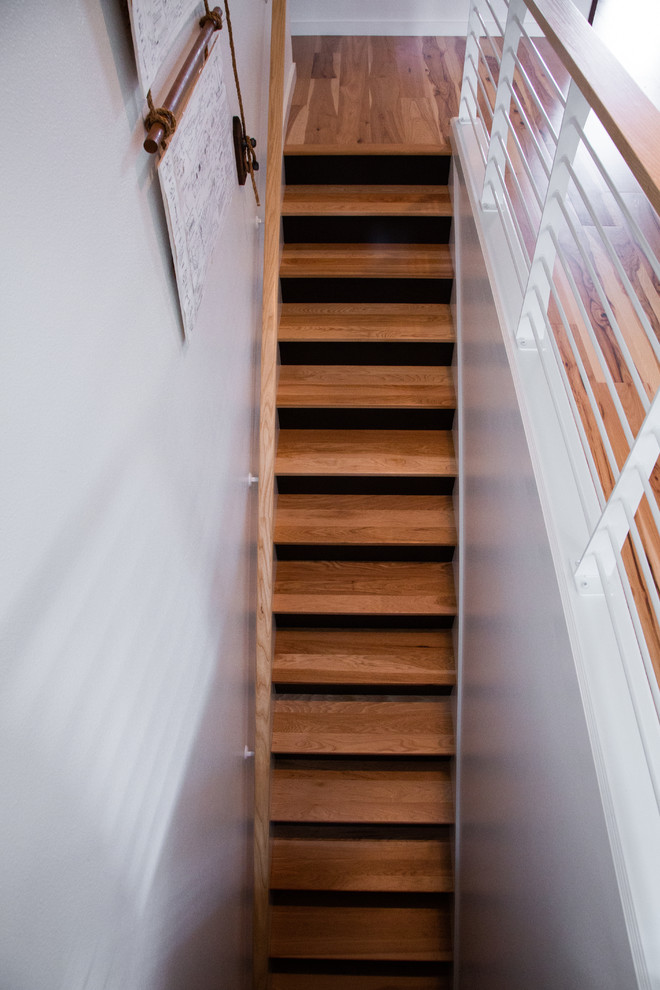 This is an example of a mid-sized modern wood straight staircase in Portland with painted wood risers and metal railing.