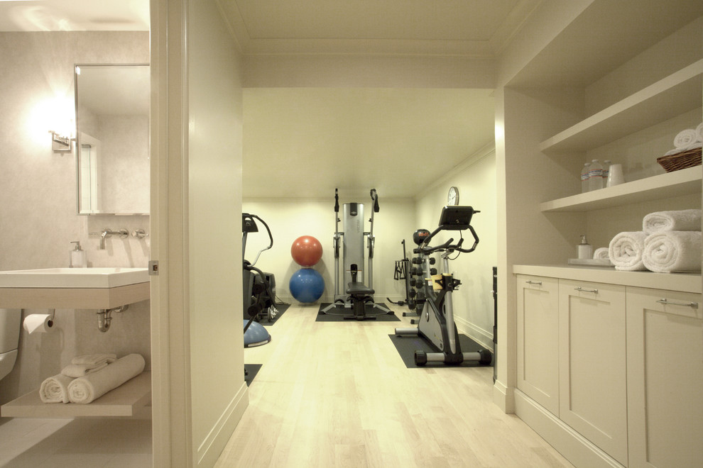 Photo of a large contemporary home weight room in Chicago with white walls and light hardwood floors.