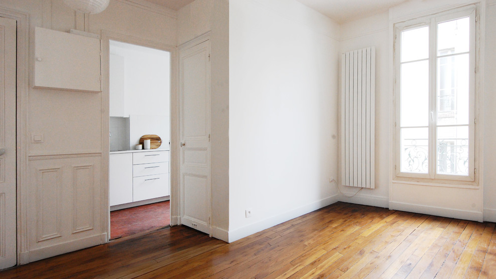 This is an example of a small traditional enclosed family room in Paris with light hardwood floors.