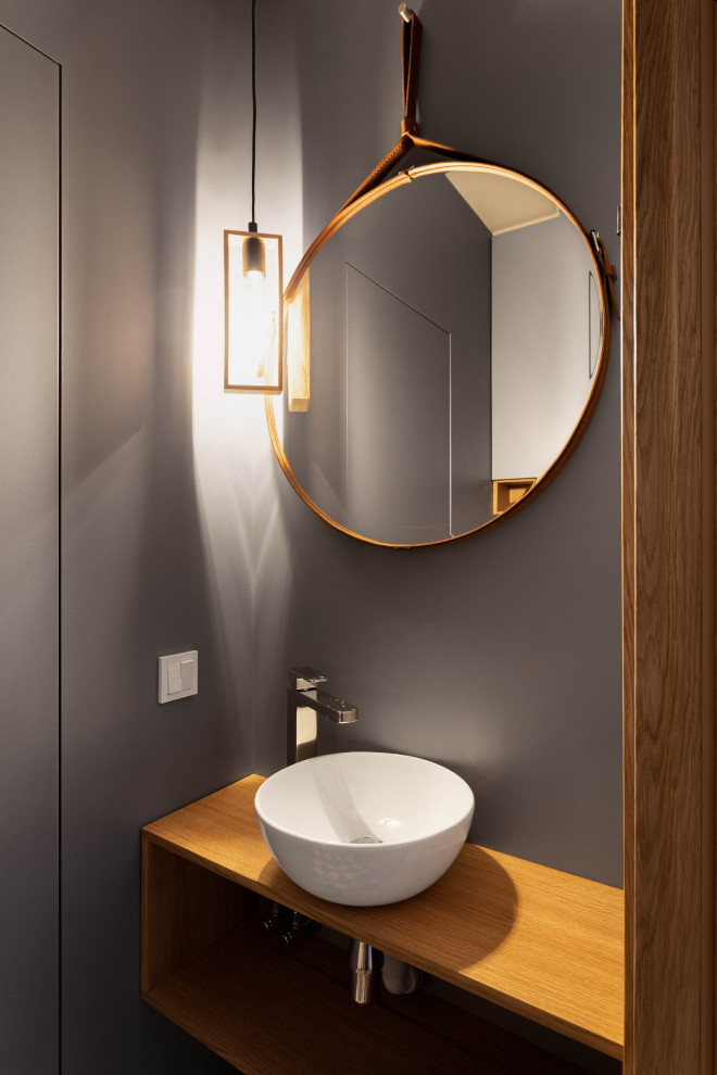 Inspiration pour un petit WC et toilettes nordique en bois brun avec un placard à porte plane, un mur bleu, un plan de toilette en bois, un plan de toilette marron et meuble-lavabo suspendu.