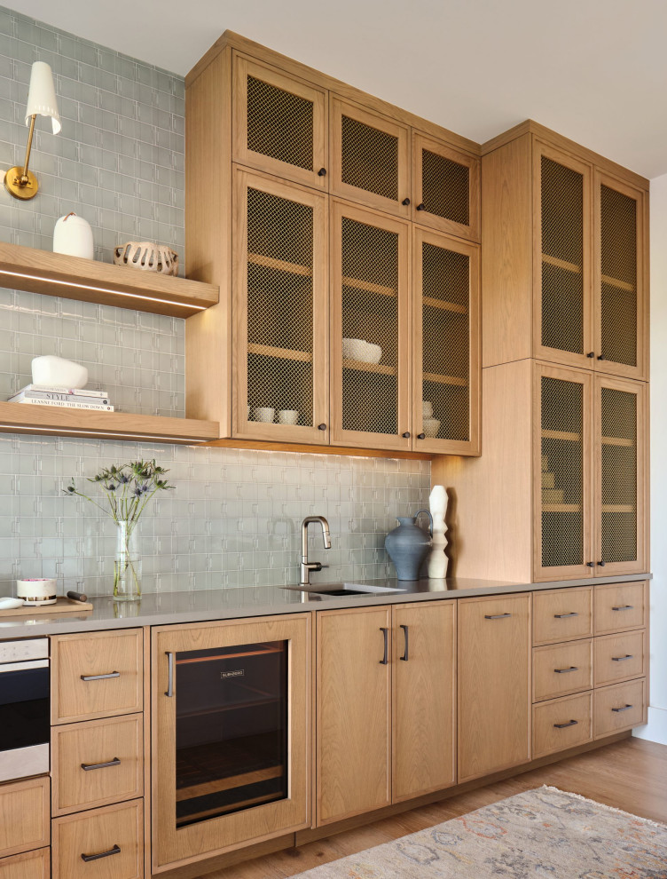 Home bar - contemporary single-wall medium tone wood floor and brown floor home bar idea in Austin with an undermount sink, shaker cabinets, light wood cabinets, gray backsplash, mosaic tile backsplash and gray countertops
